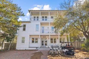 a white house with bikes parked in front of it at Soakin it Up in Inlet Beach