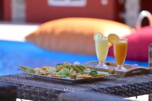 a plate of food on a table with two drinks at Palais D'orient in Sidi Bou Houria