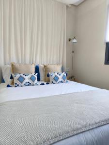 a bedroom with a bed with blue and white pillows at Cosy Flat with IPTV, BB gear Married couples only in Tangier +38 photos