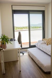 a bedroom with a desk and a desk chair and a window at Ático Premium con Azotea, Pádel y Piscina in San Jorge +31 photos