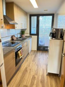 a kitchen with a sink and a stove top oven at Ático Premium con Azotea, Pádel y Piscina in San Jorge