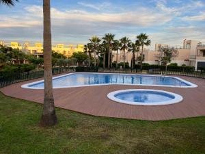 una piscina en un parque con palmeras en Ático Premium con Azotea, Pádel y Piscina, en Sant Jordi (San Jorge)