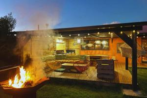 a fire grill in a backyard with a table and chairs at L'Hacienda - A la chambre - 10 pers - Wiskeys in Le Tampon