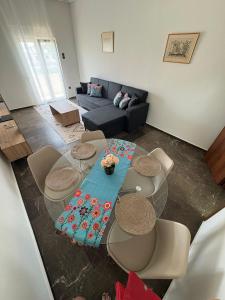 ein Wohnzimmer mit Tisch und Couch in der Unterkunft SMYRNA HOMES KALYOPi in Chios