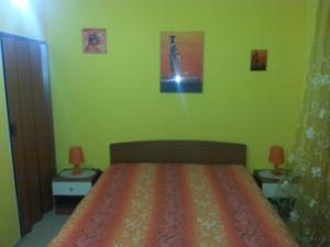 una camera da letto con un letto con pareti verdi e due tavoli di B&B La Collina a Collepasso