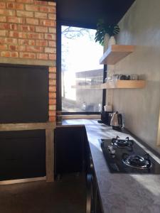 a kitchen with a stove and a brick wall at Luxury Villa in Windhoek with Private Pool in Khomas Region