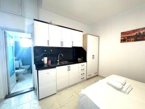 a kitchen with white cabinets and a sink at Taku Rooms Vlora 3 in Vlorë