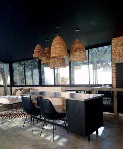 a room with a table and chairs and windows at Luxury Villa in Windhoek with Private Pool in Khomas Region