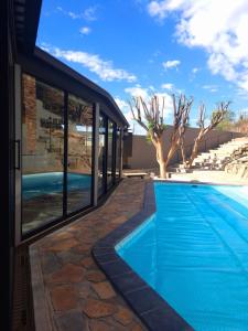 a swimming pool in front of a building at Luxury Villa in Windhoek with Private Pool in Khomas Region