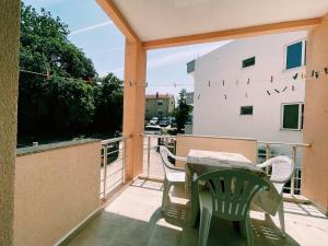 a patio with a table and chairs on a balcony at Guest House Koliqi - Hotel & Apartments in Ulcinj