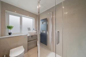a bathroom with a shower and a toilet and a sink at Cosy 3 BEDROOM Home with Garden, Ealing in Greenford +14 photos