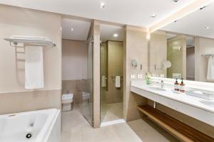 een badkamer met 2 wastafels, een douche en een toilet bij Palmaroga Hotel Asuncion, Tapestry Collection by Hilton in Asuncion