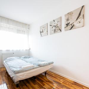 a bedroom with a bed and three pictures on the wall at TP Spacious Stylish Free parking in Szeged