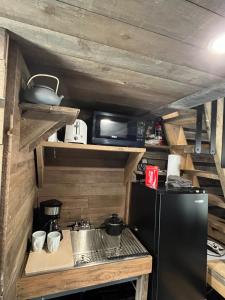 a kitchen with a black refrigerator and a stove at Rustic Guesthouse in Sayward