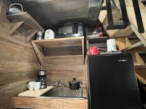 a small kitchen with a sink and a refrigerator at Rustic Guesthouse in Sayward