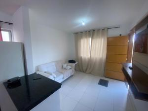 a living room with a white couch and a table at Apartment - Pedro Leopoldo in Pedro Leopoldo +7 photos