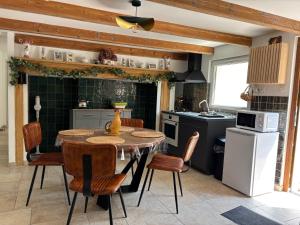 a kitchen with a table and chairs in a room at Havre de Paix in Hermelinghen