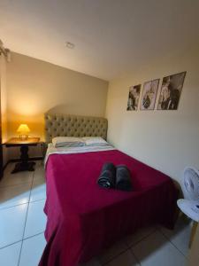 a bedroom with a bed with two pairs of shoes on it at Aconchego de Itaipava - casa de 3 quartos, equipada, área kids, jacuzzi, pet friendly, churrasqueira, em meio a Natureza e próximo ao centro do bairro in Araras Petropolis