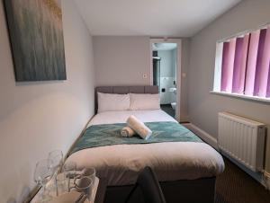 a small bedroom with a bed with a towel on it at Newcastle - Gateshead Rooms in Newcastle upon Tyne