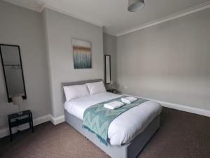 a bedroom with a bed with two towels on it at Newcastle - Gateshead Rooms in Newcastle upon Tyne