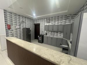 a large kitchen with gray cabinets and a counter at Luxury apartment, 3 bedrooms, living room, kitchen in Jeddah +8 photos