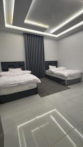 a bedroom with two beds and a window in it at Luxury apartment, 3 bedrooms, living room, kitchen in Jeddah