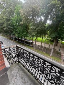 a bench on a balcony with a train on the street at Studio Lilia in Brussels +4 photos