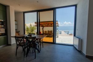 a dining room with a table and a view of the ocean at Vila Kladenci in Radožda