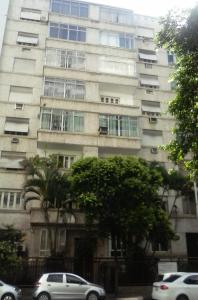 a tall building with cars parked in front of it at Apartamento Nossa Senhora in Rio de Janeiro