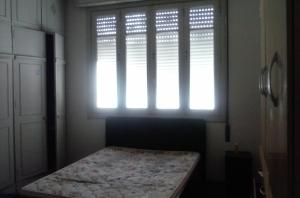リオデジャネイロにあるApartamento Nossa Senhoraの窓付きのベッドルーム1室、ベッド1台が備わります。