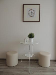 a table with two stools and a table with a plant at Kosovic Family House in Medulin