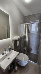 un bagno con doccia, lavandino e WC di A Minute to the Sea Brela a Brela