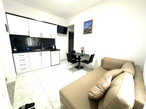 a living room with a couch and a kitchen at Taku Rooms Vlora 2 in Vlorë