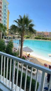 a view of a pool with a palm tree and a beach at Luxurious Family Chalet - Sia Lagoon, Porto Golf Marina, El Alamien - Lagoon View in El Alamein