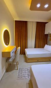 a bedroom with two beds and a desk and a chair at Luxurious Family Chalet - Sia Lagoon, Porto Golf Marina, El Alamien - Lagoon View in El Alamein