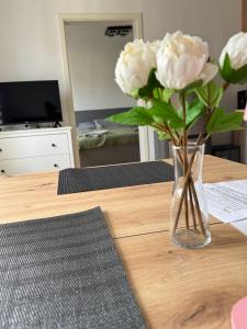 a vase of white flowers sitting on a table at Zentrales Apartment mit Netflix, Kaffee & Parkplätzen in Paderborn