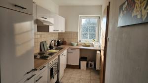 UlmerfeldにあるApartment im Zentrum Ulmerfeldsの小さなキッチン(白いキャビネット付)、窓 +17枚の写真