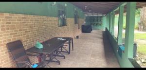 a patio with a table and chairs and a brick wall at Sitiobbb in Ananindeua