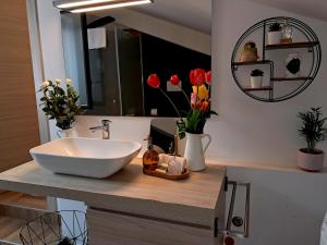 ein Badezimmer mit einem Waschbecken und Blumen auf der Theke in der Unterkunft OLTREMARE holiday home in Catania + 26 Fotos