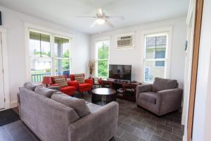 a living room with a couch and chairs and a tv at The Milkweed - 18 Meadow View in Cherry Valley