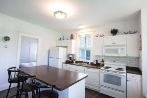 a kitchen with white appliances and a table and chairs at The Milkweed - 18 Meadow View in Cherry Valley