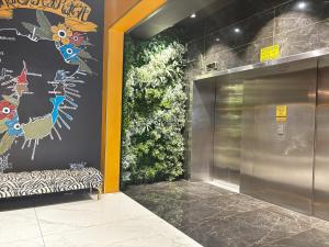 Un vestíbulo con una puerta de metal con una pintura en la pared. en ONOMO Hotel Foreshore, en Ciudad del Cabo 27 fotos más
