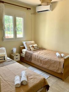 a bedroom with two beds and a window at Plagia Oasis Escape in Nea Plagia