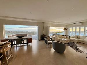 a large living room with a table and couches at Jonesy's Place on the Beach in Yzerfontein