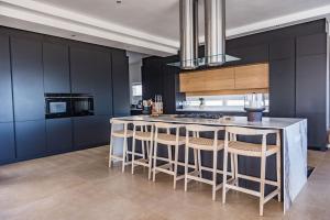 a kitchen with a island with bar stools at Jonesy's Place on the Beach in Yzerfontein