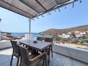 a table and chairs on a balcony with a view of the ocean at Sea view Lefkes in Kithnos