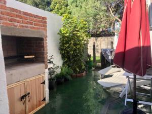 a pool of water in a backyard with a table and umbrella at Casa-Apt de 2 Dormitorios Perfecta Ubicacion in Piriápolis