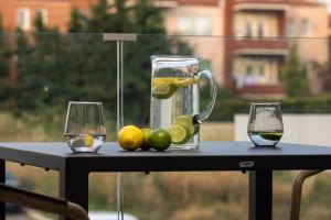 a drink pitcher and two glasses on a table at Nemausa Luxury Living in Kallithea Halkidikis