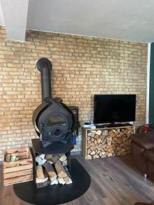 ein Ofen in einem Wohnzimmer mit einer Ziegelwand in der Unterkunft FERIENHAUS ZUM BULLERJAN - Coozy Haus mit Kamin in EuÃŸerthal
