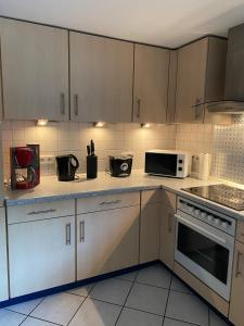 eine Küche mit weißen Schränken und weißen Geräten in der Unterkunft FERIENHAUS ZUM BULLERJAN - Coozy Haus mit Kamin in EuÃŸerthal